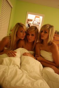 drei-sehr-sexy-junge-blondinen-nackt-in-einem-bett