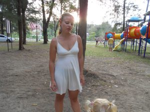 sexy-mutter-im-kleid-mit-nippelalarm-auf-einem-spielplatz